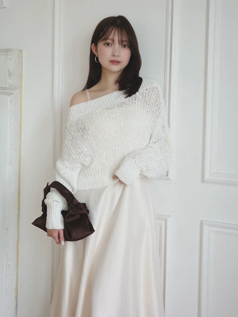 ホワイト系のワンピース、ベージュ系のパンプスを着用したレディースの冬コーディネートの2枚目の写真