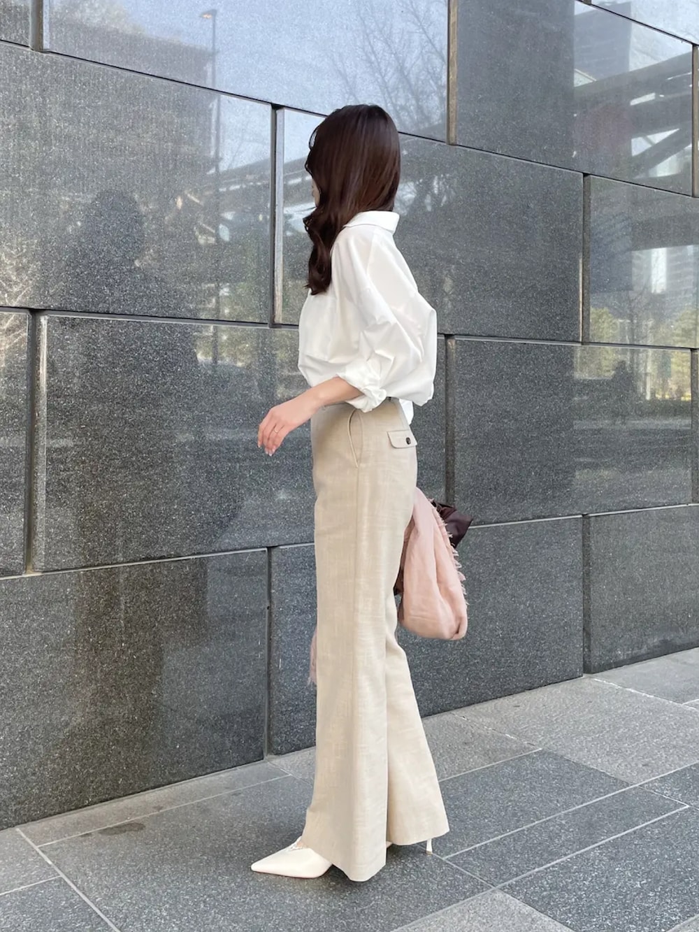 ホワイト系のシャツ/ブラウス、ベージュ系のスラックスを着用したレディースの春コーディネートの3枚目の写真