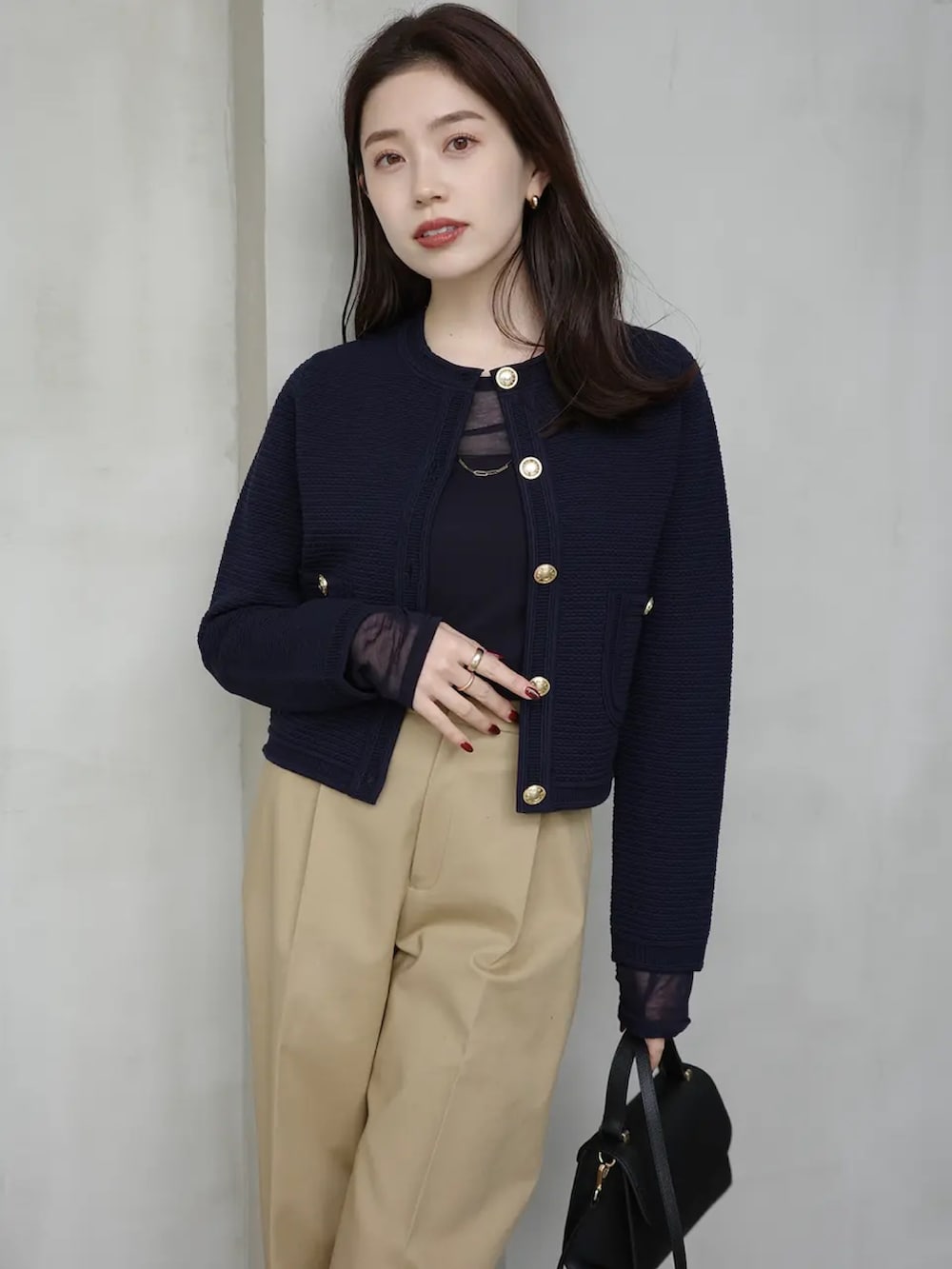 ブルー系のTシャツ/カットソー、ベージュ系のその他パンツ、ブラック系のノーカラージャケットを着用したレディースの冬コーディネートの2枚目の写真