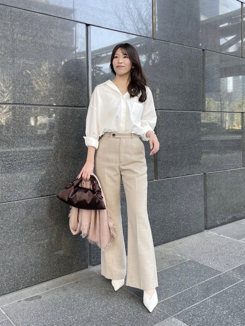 ホワイト系のシャツ/ブラウス、ベージュ系のスラックスを着用したレディースの春コーディネートの2枚目の写真