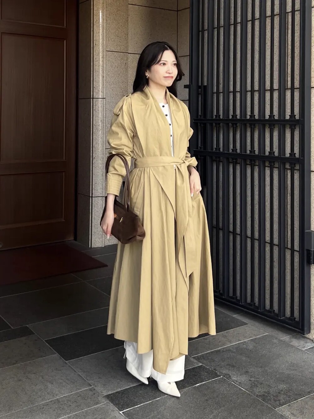 ベージュ系のトレンチコート、ホワイト系のカーディガン/ボレロ、ホワイト系のその他パンツを着用したレディースの冬コーディネートの2枚目の写真