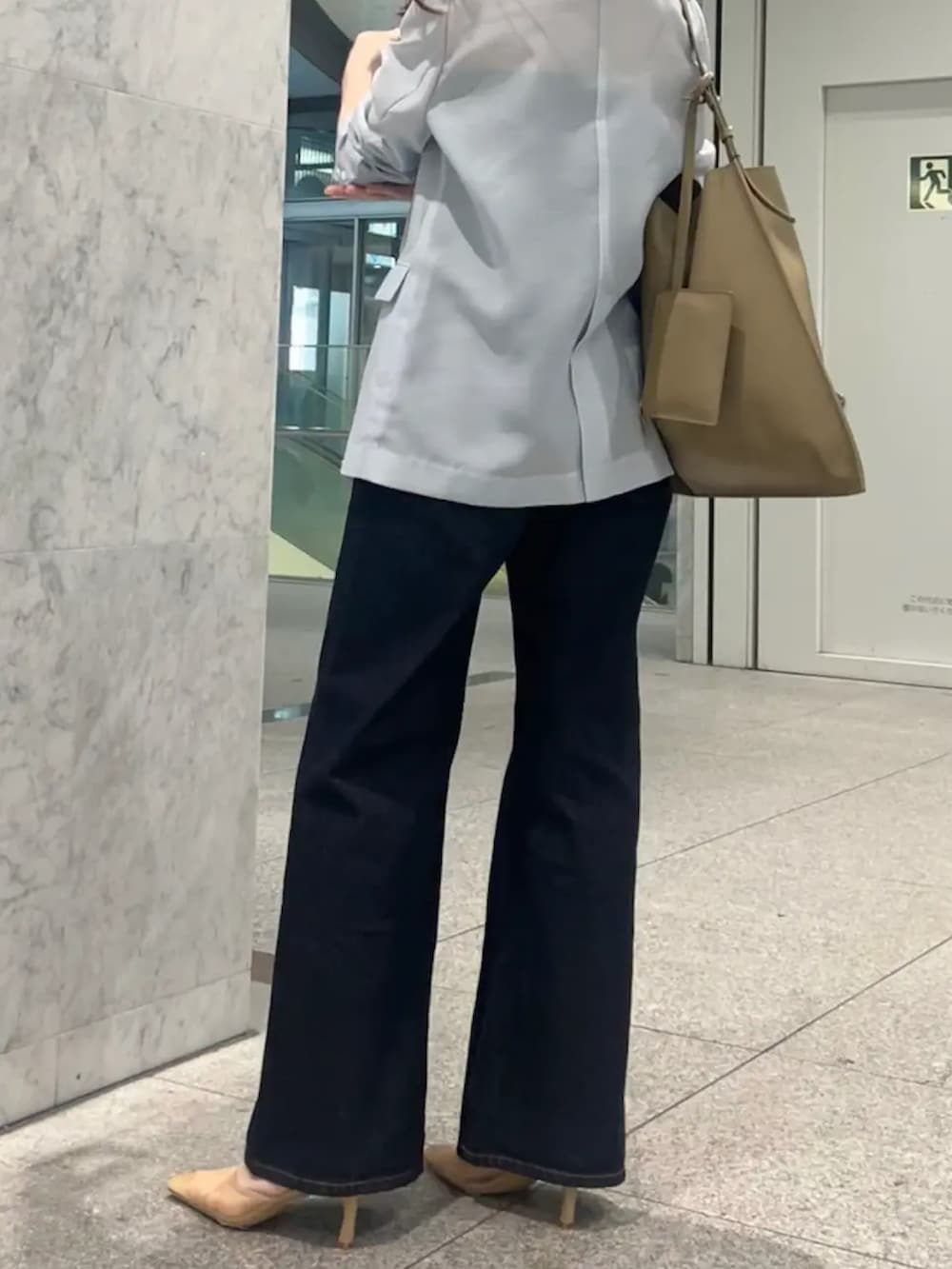 ブルー系のテーラードジャケットを着用したレディースの春コーディネートの3枚目の写真