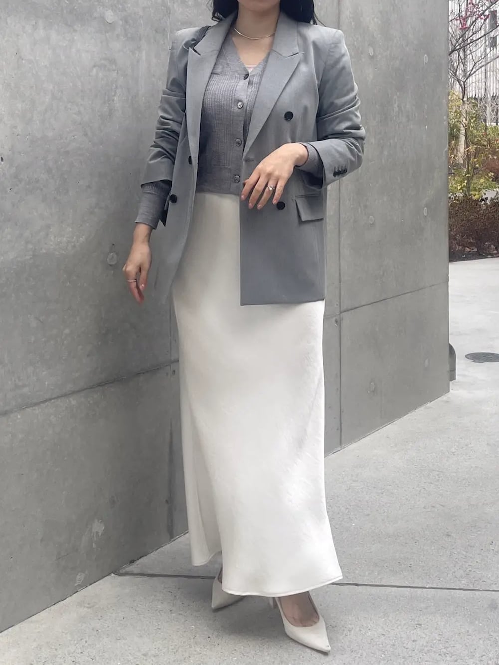 グレー系のカーディガン/ボレロ、グレー系のテーラードジャケット、ホワイト系のスカートを着用したレディースの冬コーディネートの2枚目の写真