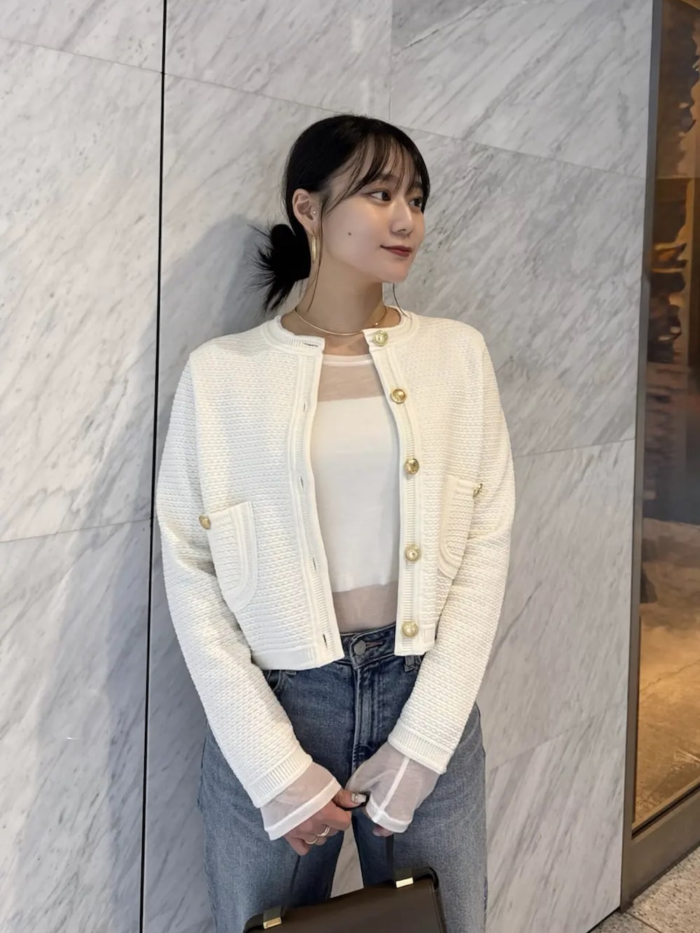 ホワイト系のTシャツ/カットソー、ホワイト系のノーカラージャケット、ブルー系のデニムパンツを着用したレディースの冬コーディネートの3枚目の写真