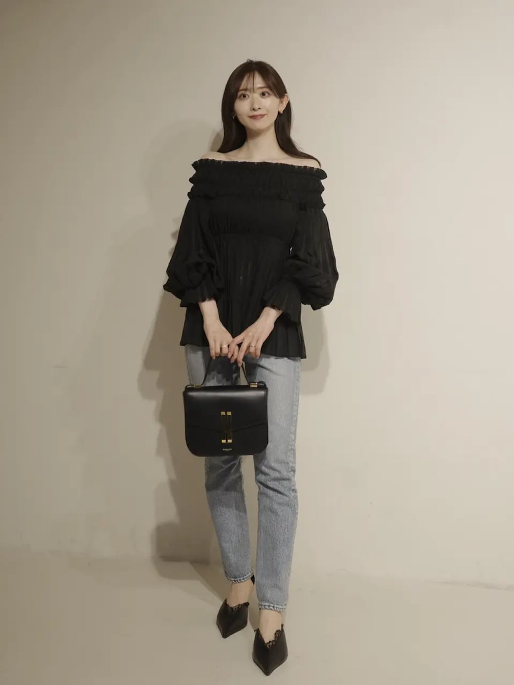 ブラック系のシャツ/ブラウス、ブルー系のデニムパンツを着用したレディースの冬コーディネートの2枚目の写真