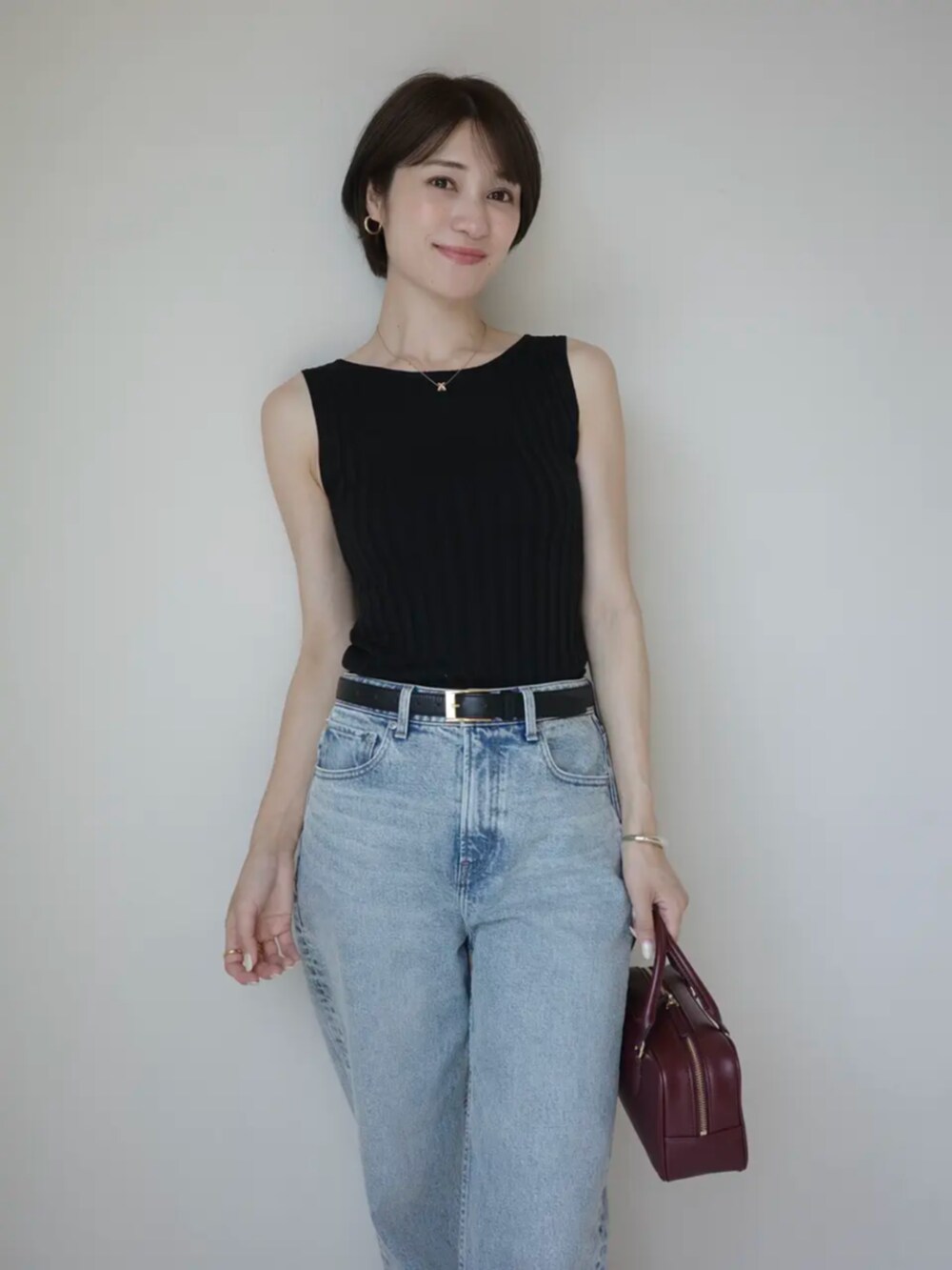 ブルー系のデニムパンツ、ブラック系のニット/セーターを着用したレディースの夏コーディネートの3枚目の写真