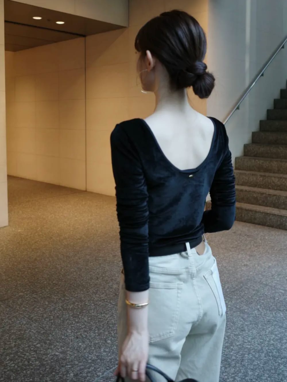 ベージュ系のデニムパンツ、ブラック系のボストンバッグ、ブラック系のパンプスを着用したレディースの夏コーディネートの3枚目の写真