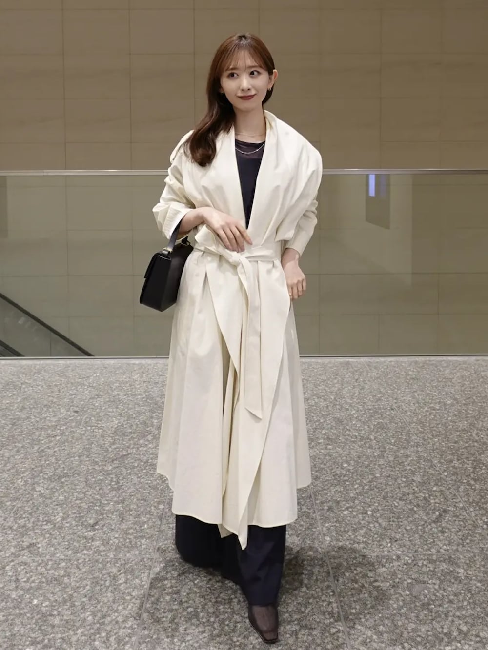 ホワイト系のトレンチコート、ブルー系のTシャツ/カットソー、ブルー系のその他パンツを着用したレディースの冬コーディネートの3枚目の写真