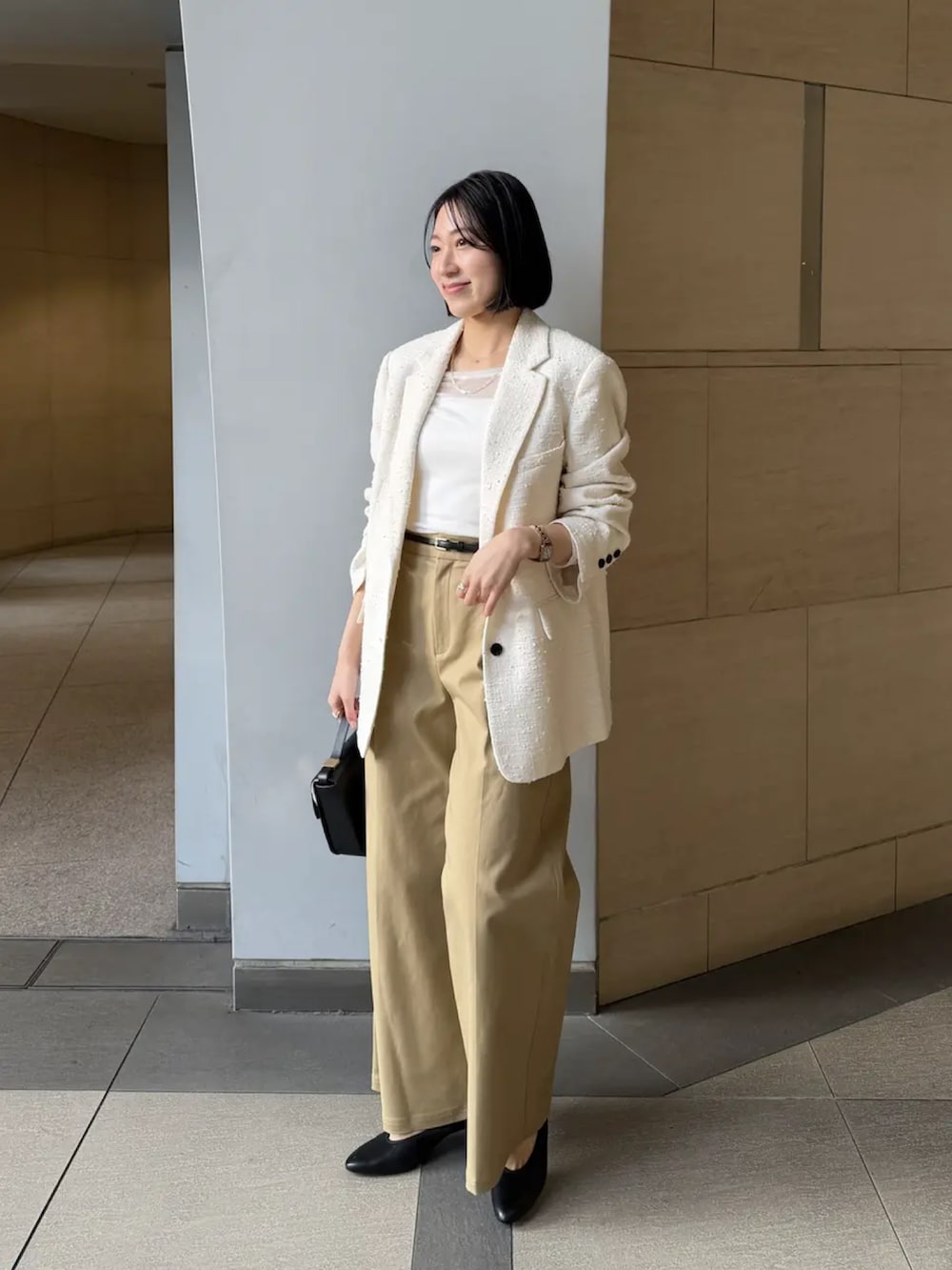 ホワイト系のその他アウター、ホワイト系のTシャツ/カットソー、ベージュ系のその他パンツを着用したレディースの冬コーディネートの2枚目の写真