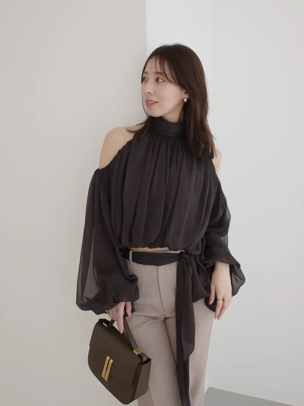 ブラウン系のシャツ/ブラウス、ベージュ系のスラックスを着用したレディースの春コーディネートの4枚目の写真