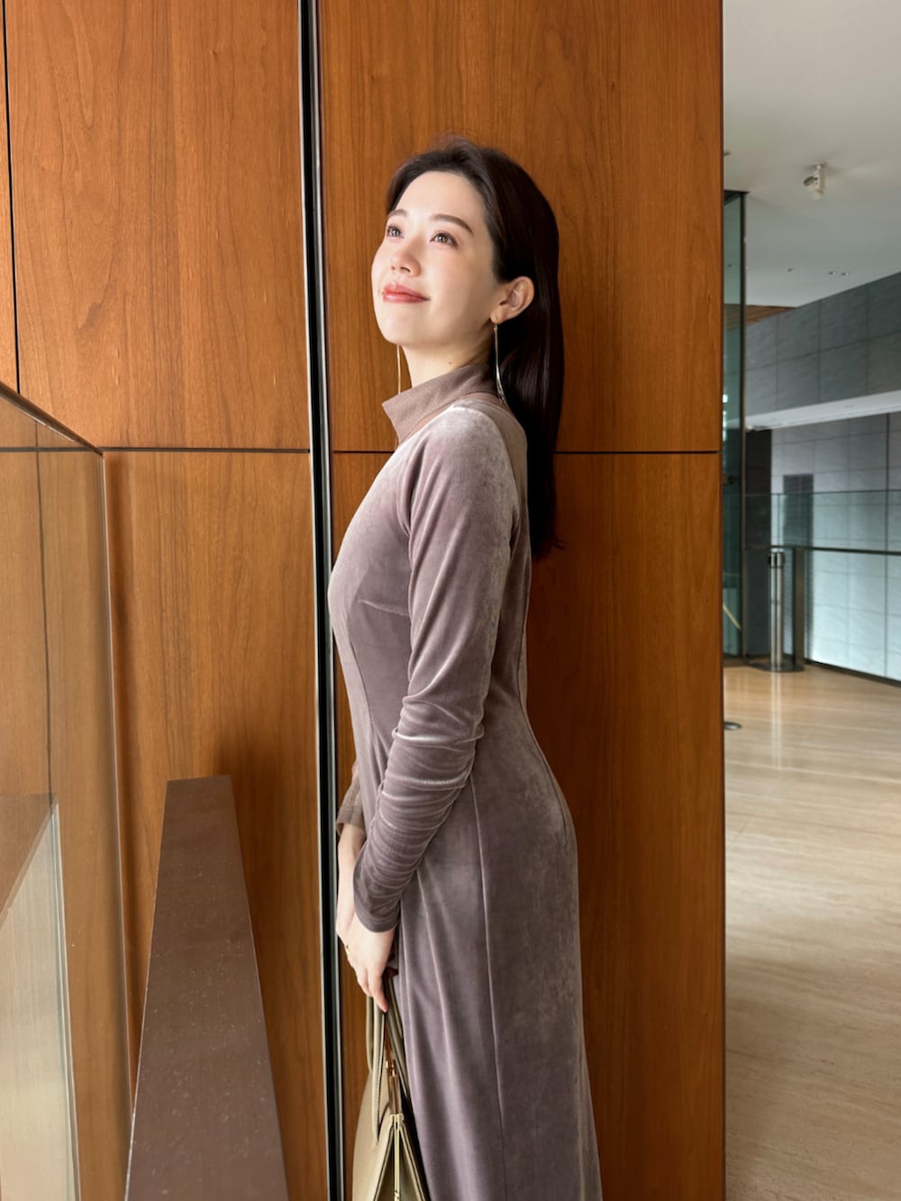 ベージュ系のハンドバッグ、ブラック系のブーツ、ベージュ系のワンピースを着用したレディースの冬コーディネートの4枚目の写真