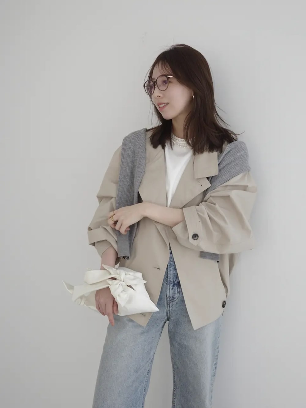 ブルー系のデニムパンツ、ベージュ系のブルゾン、グレー系のカーディガン/ボレロを着用したレディースの春コーディネートの5枚目の写真