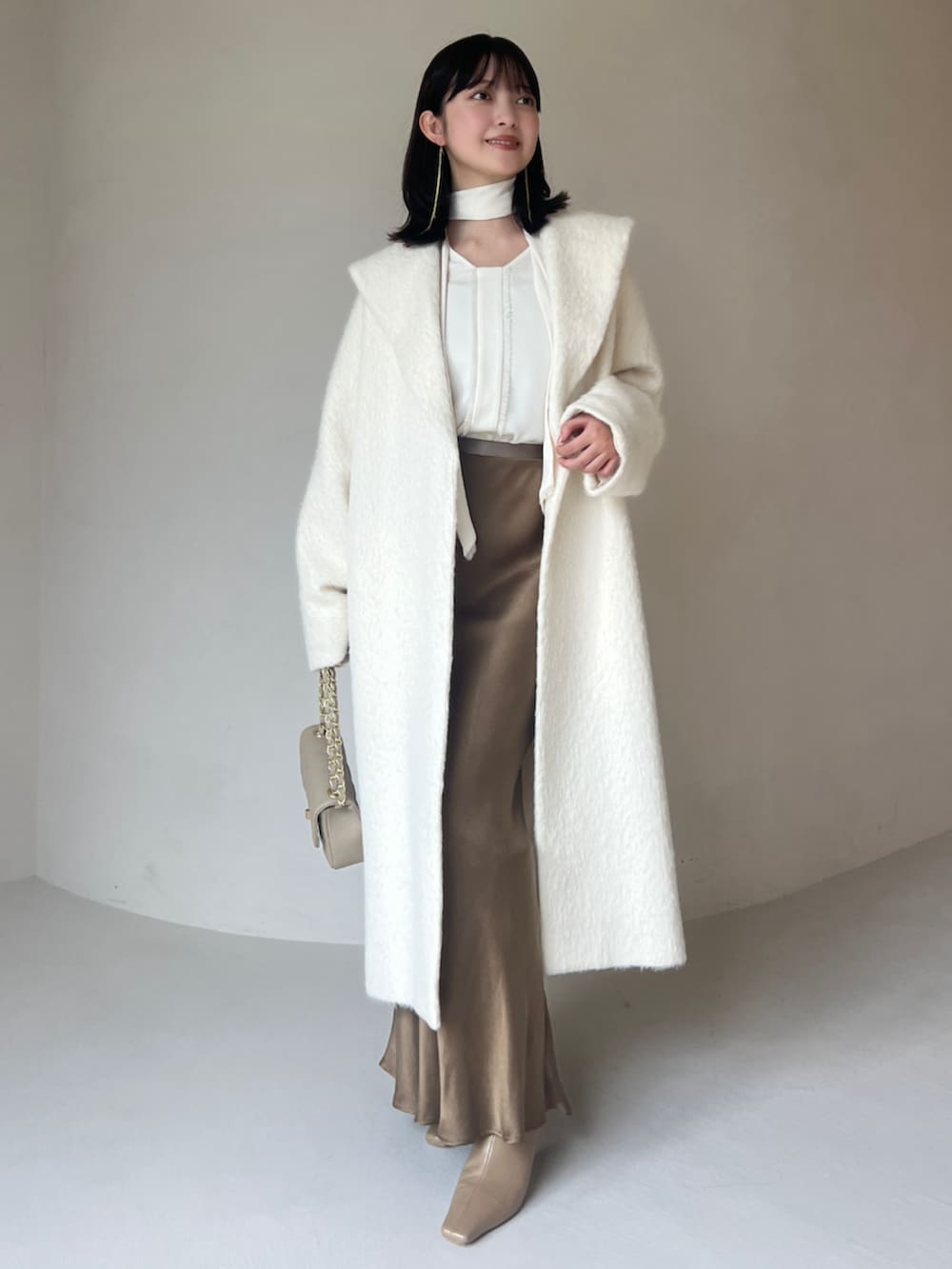 グレー系のその他アウター、ホワイト系のその他アウター、ホワイト系のシャツ/ブラウスを着用したレディースの冬コーディネートの2枚目の写真