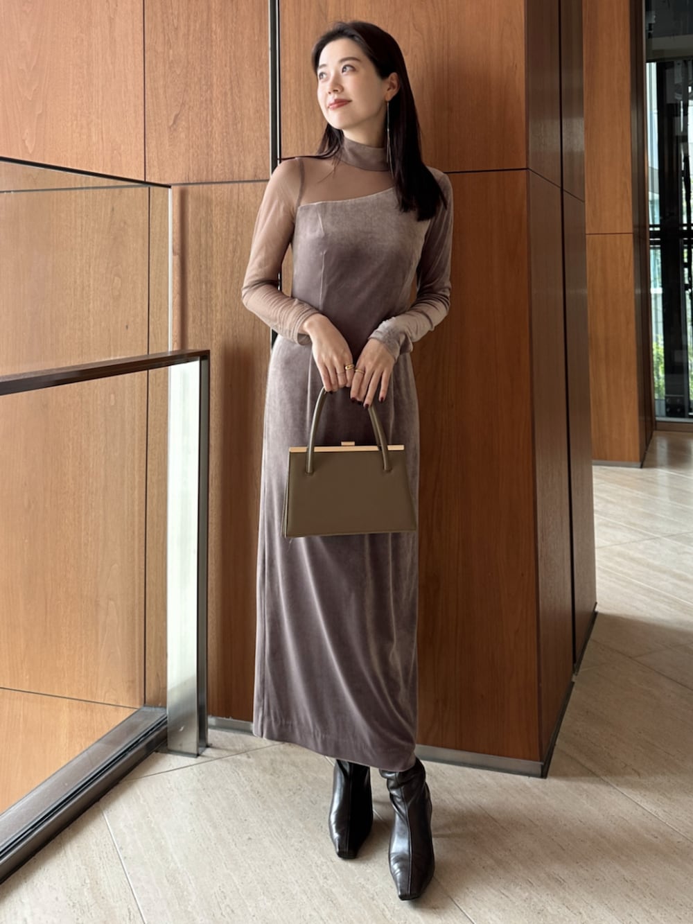 ベージュ系のハンドバッグ、ブラック系のブーツ、ベージュ系のワンピースを着用したレディースの冬コーディネートの2枚目の写真