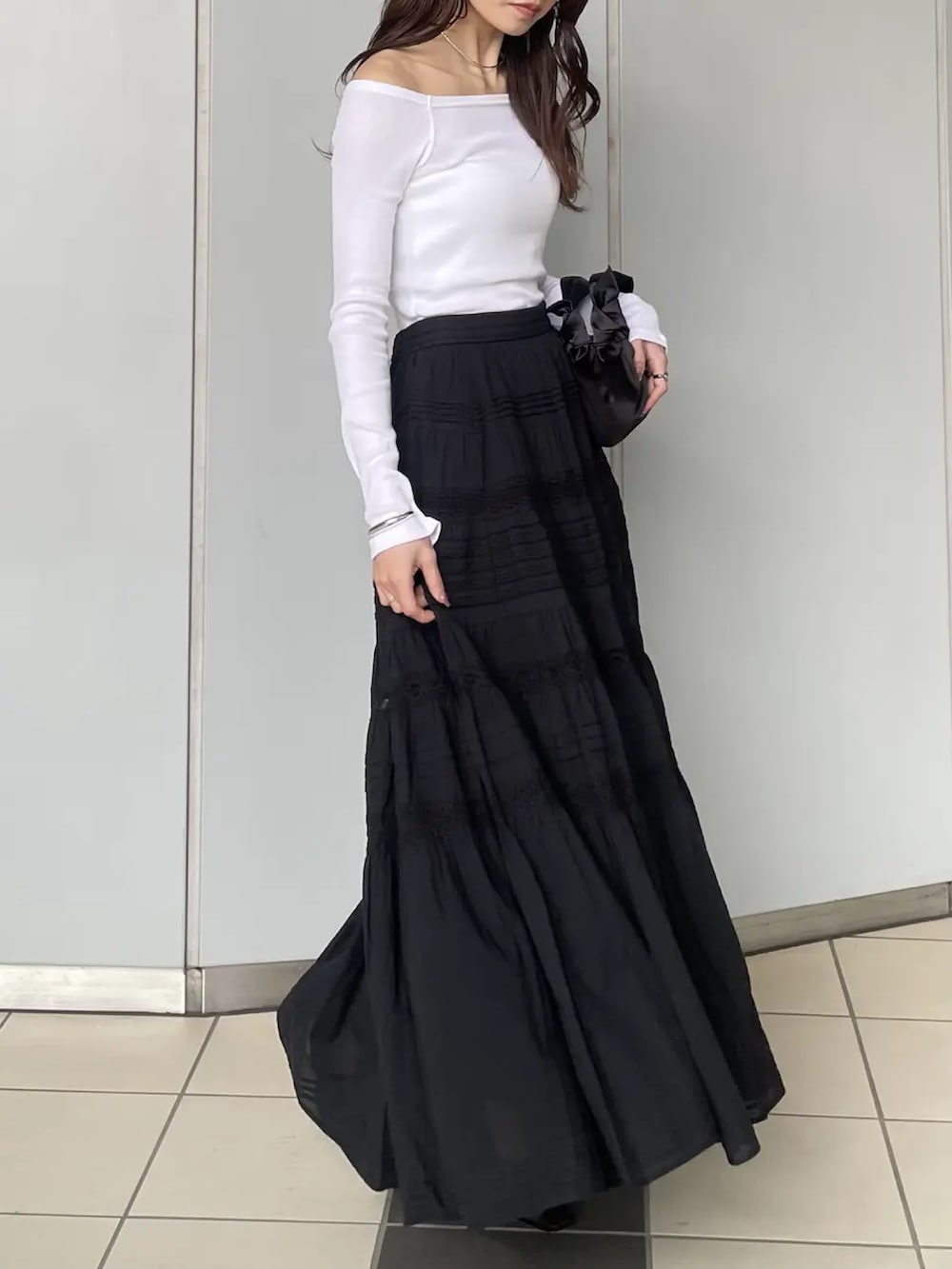 ホワイト系のTシャツ/カットソー、ブラック系のスカートを着用したレディースの春コーディネートの3枚目の写真