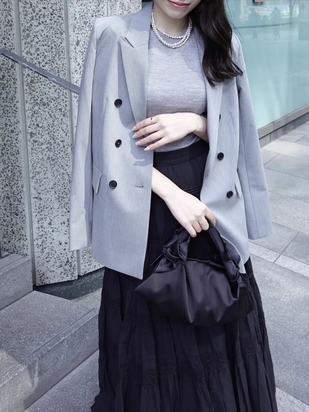 グレー系のテーラードジャケット、グレー系のその他トップス、ブラック系のスカートを着用したレディースの春コーディネートの4枚目の写真