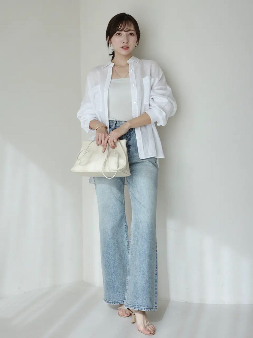 ホワイト系のシャツ/ブラウス、ブルー系のデニムパンツを着用したレディースの春コーディネートの2枚目の写真