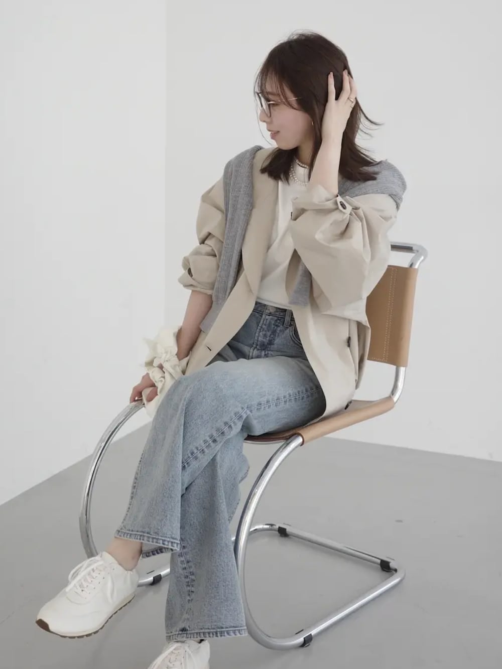 ブルー系のデニムパンツ、ベージュ系のブルゾン、グレー系のカーディガン/ボレロを着用したレディースの春コーディネートの2枚目の写真