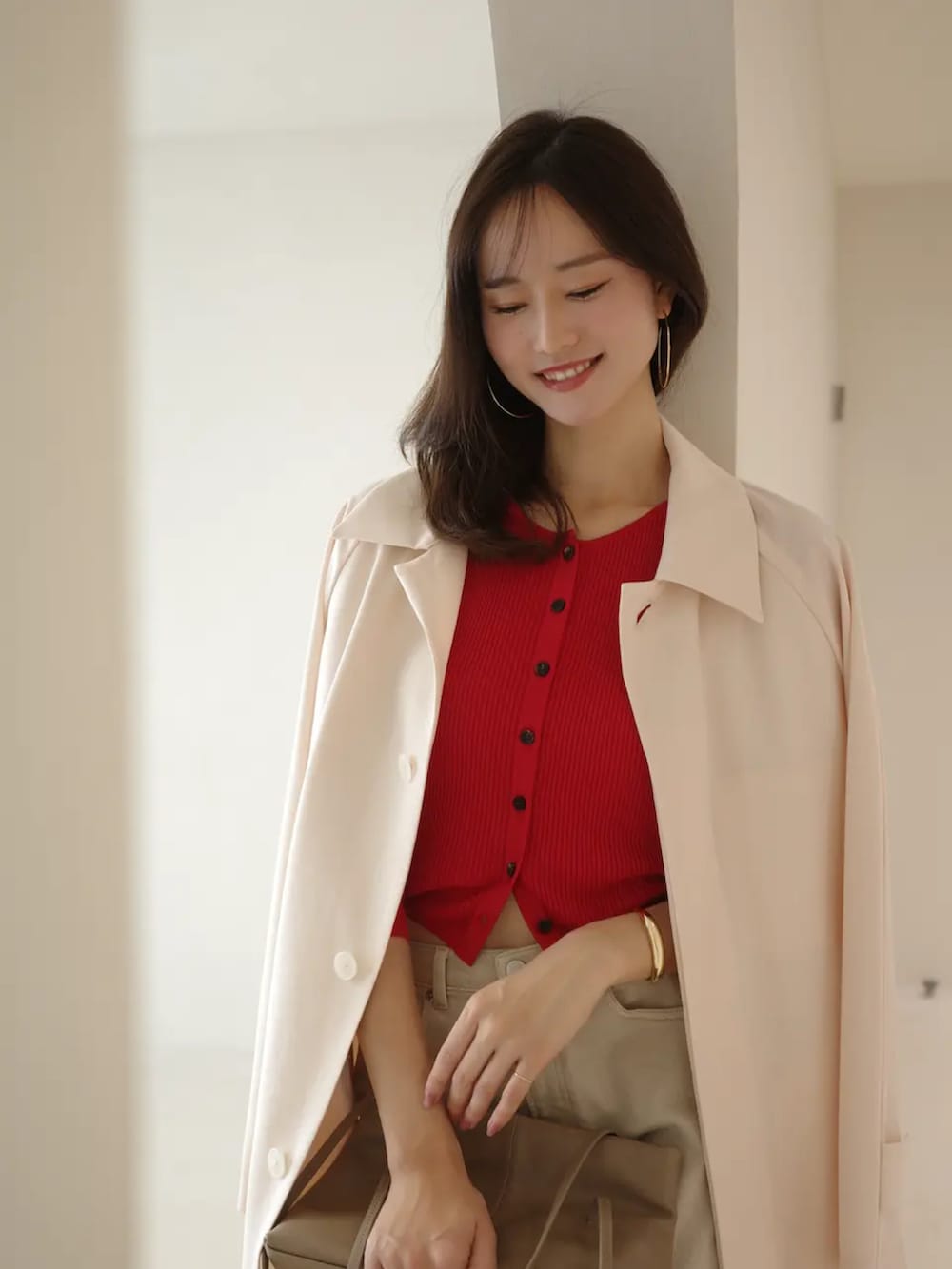 レッド系のカーディガン/ボレロ、ベージュ系のデニムパンツ、ピンク系のステンカラーコートを着用したレディースの春コーディネートの4枚目の写真