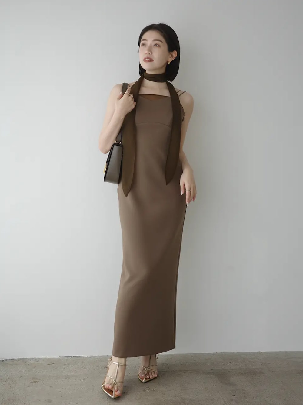 ブラウン系のワンピースを着用したレディースの春コーディネートの2枚目の写真