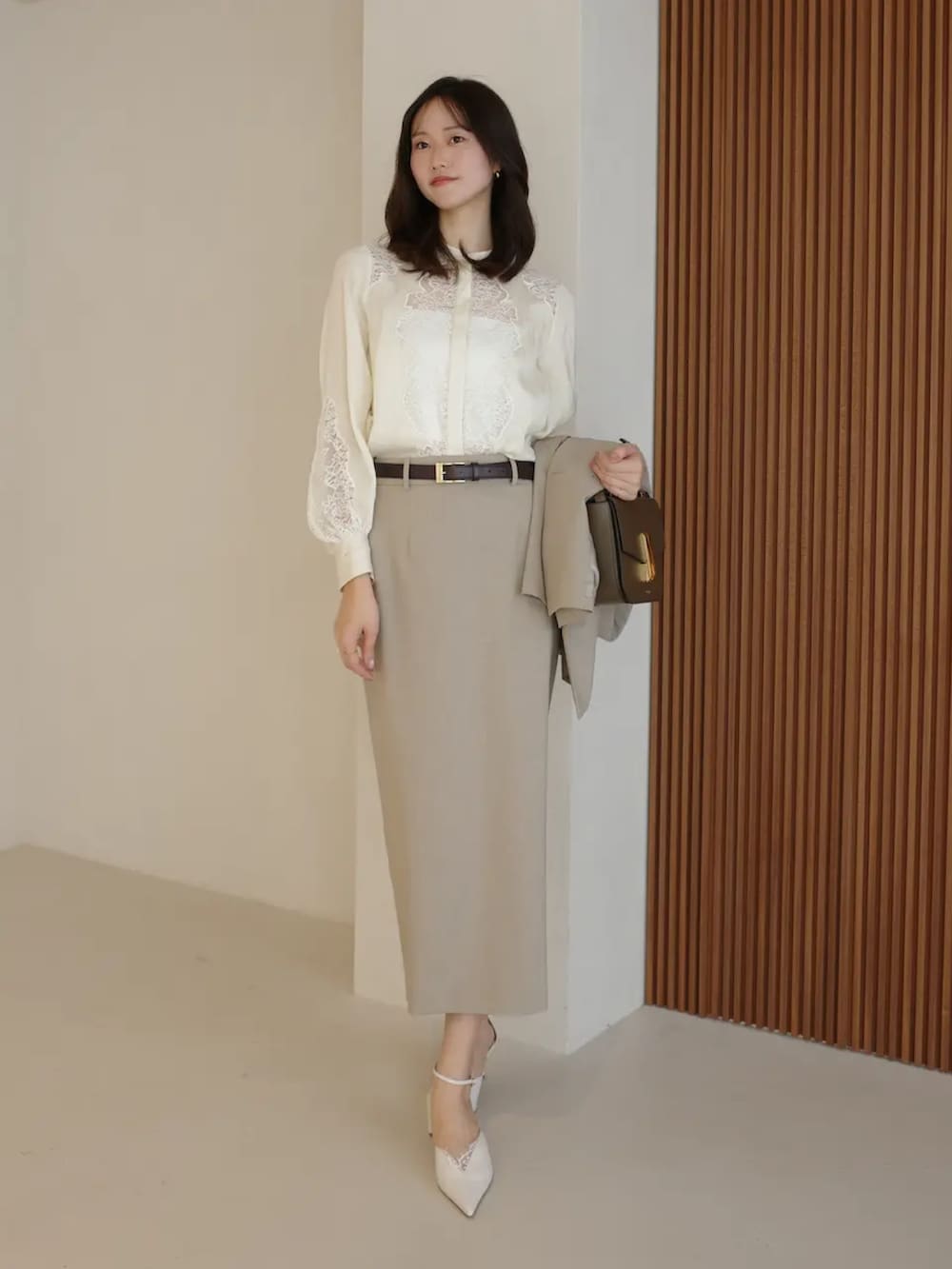 ベージュ系のテーラードジャケット、ホワイト系のシャツ/ブラウス、ベージュ系のスカートを着用したレディースの春コーディネートの2枚目の写真