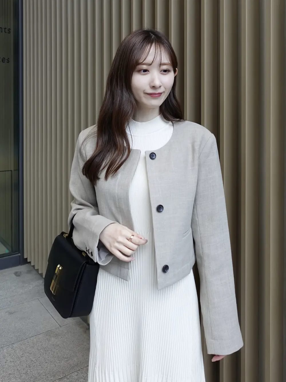 ホワイト系のワンピース、ベージュ系のノーカラージャケットを着用したレディースの春コーディネートの3枚目の写真