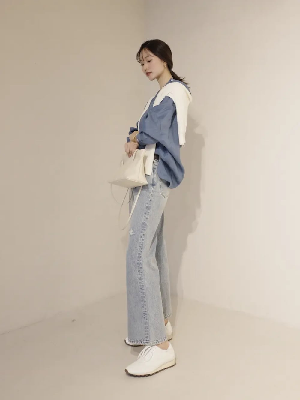 ブルー系のシャツ/ブラウス、ホワイト系のカーディガン/ボレロ、ブルー系のデニムパンツを着用したレディースの冬コーディネートの2枚目の写真