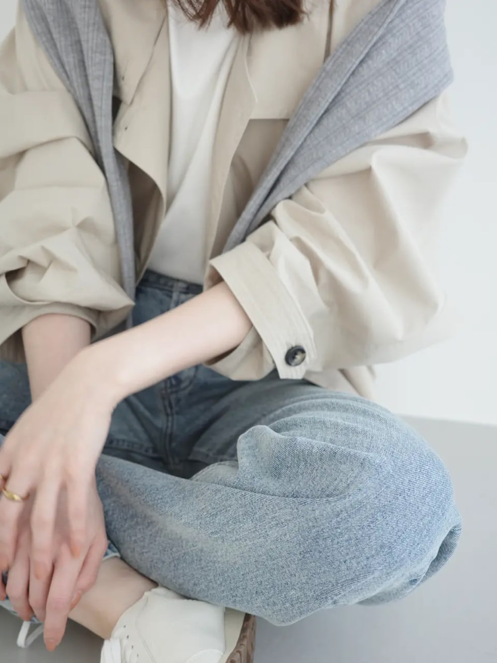 ブルー系のデニムパンツ、ベージュ系のブルゾン、グレー系のカーディガン/ボレロを着用したレディースの春コーディネートの4枚目の写真