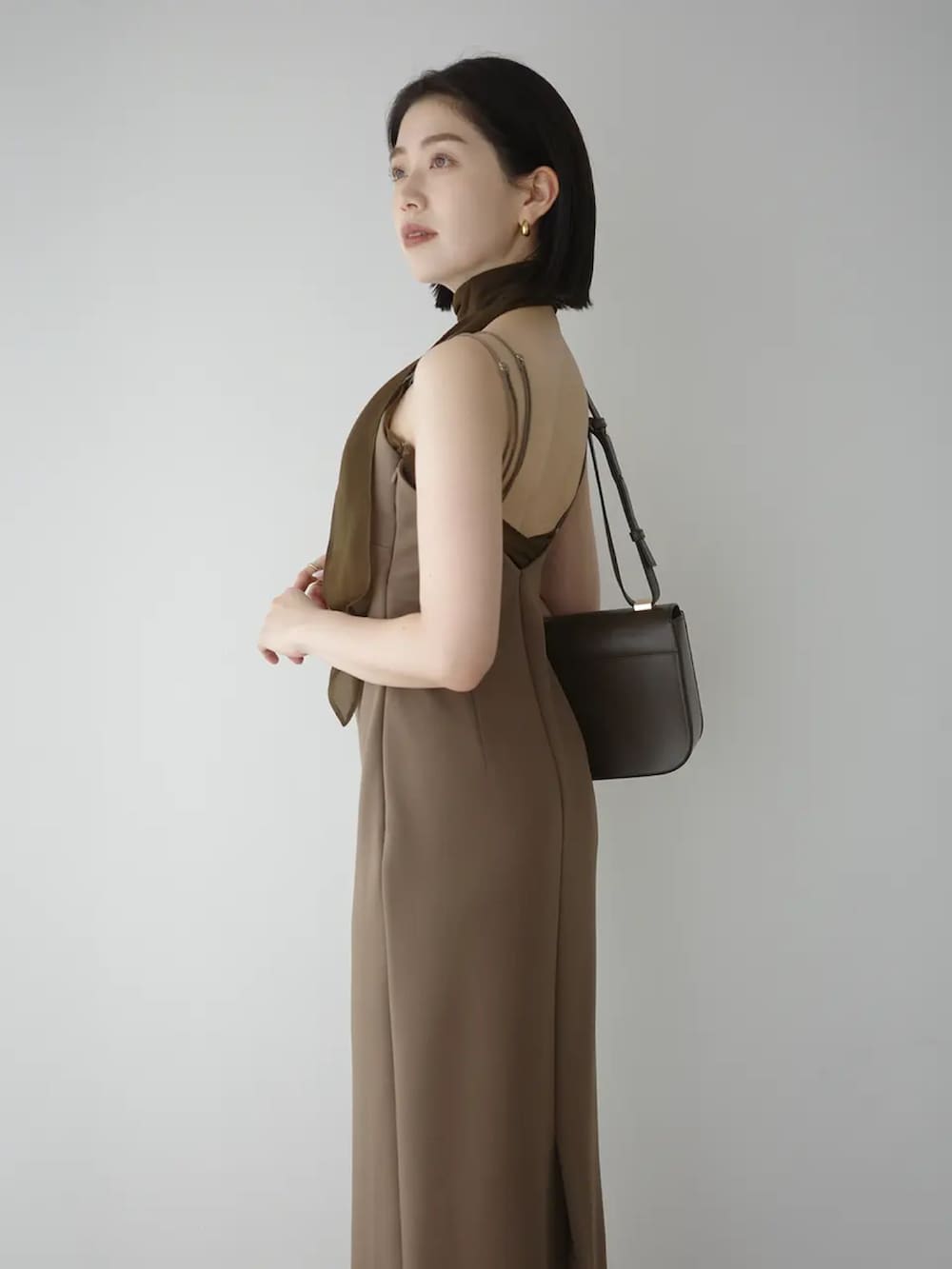 ブラウン系のワンピースを着用したレディースの春コーディネートの3枚目の写真