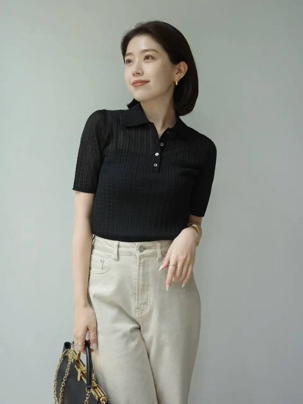 ベージュ系のデニムパンツ、ブラック系のニット/セーターを着用したレディースの夏コーディネートの3枚目の写真