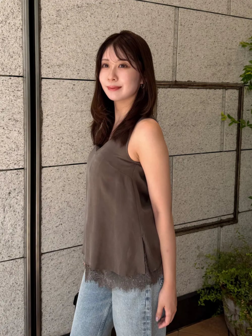 ブラック系のハンドバッグ、ブルー系のデニムパンツ、グレー系のTシャツ/カットソーを着用したレディースの夏コーディネートの2枚目の写真