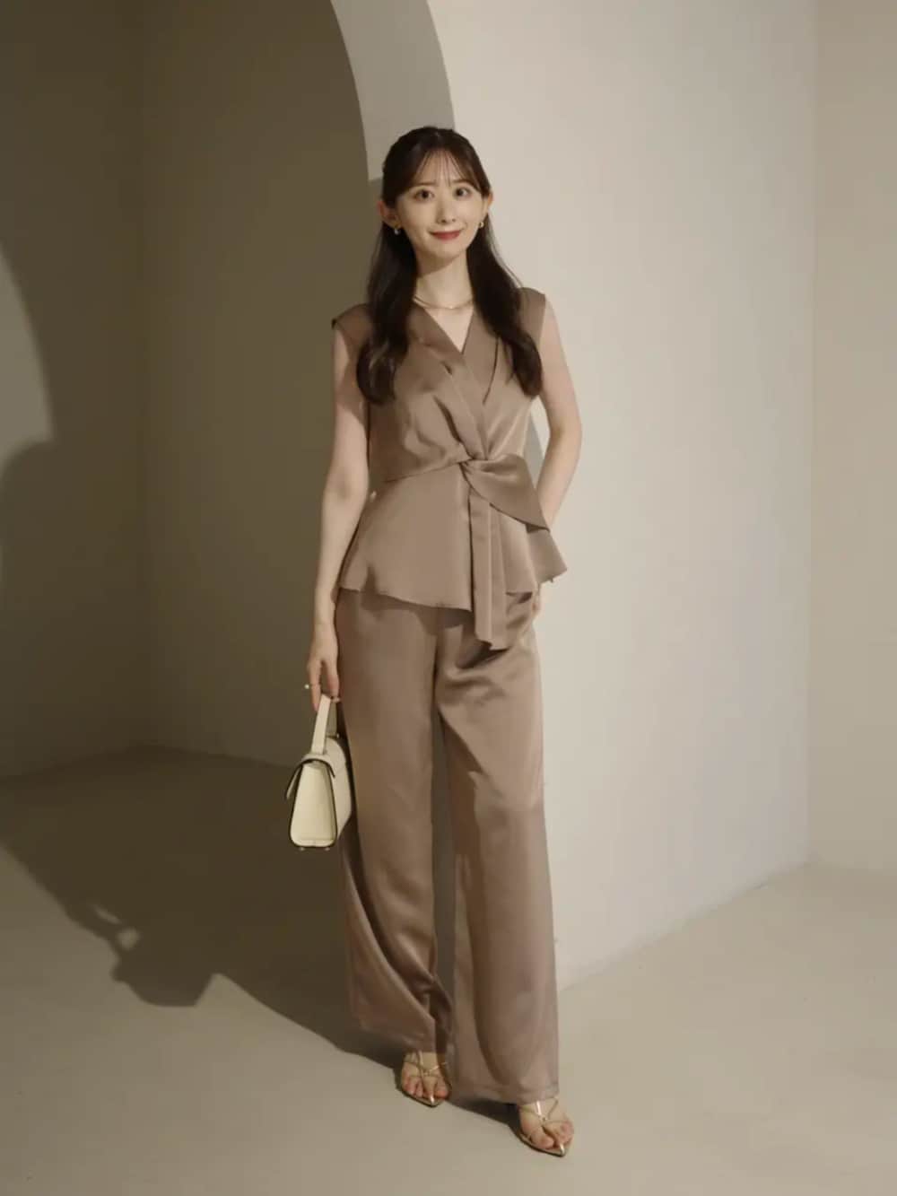 ホワイト系のハンドバッグ、ベージュ系のその他パンツ、ベージュ系のシャツ/ブラウスを着用したレディースの夏コーディネートの4枚目の写真
