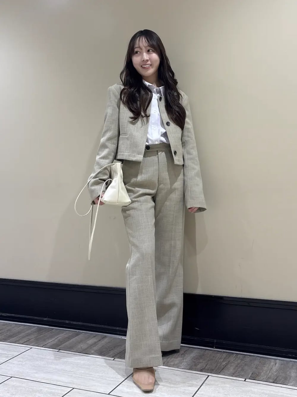 ベージュ系のスラックス、ベージュ系のノーカラージャケット、パープル系のシャツ/ブラウスを着用したレディースの春コーディネートの2枚目の写真