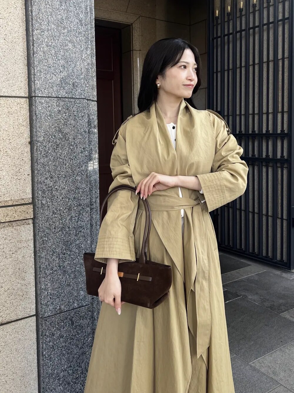 ベージュ系のトレンチコート、ホワイト系のカーディガン/ボレロ、ホワイト系のその他パンツを着用したレディースの冬コーディネートの4枚目の写真