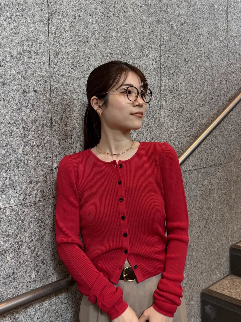 レッド系のカーディガン/ボレロ、ベージュ系のスカートを着用したレディースの冬コーディネートの2枚目の写真