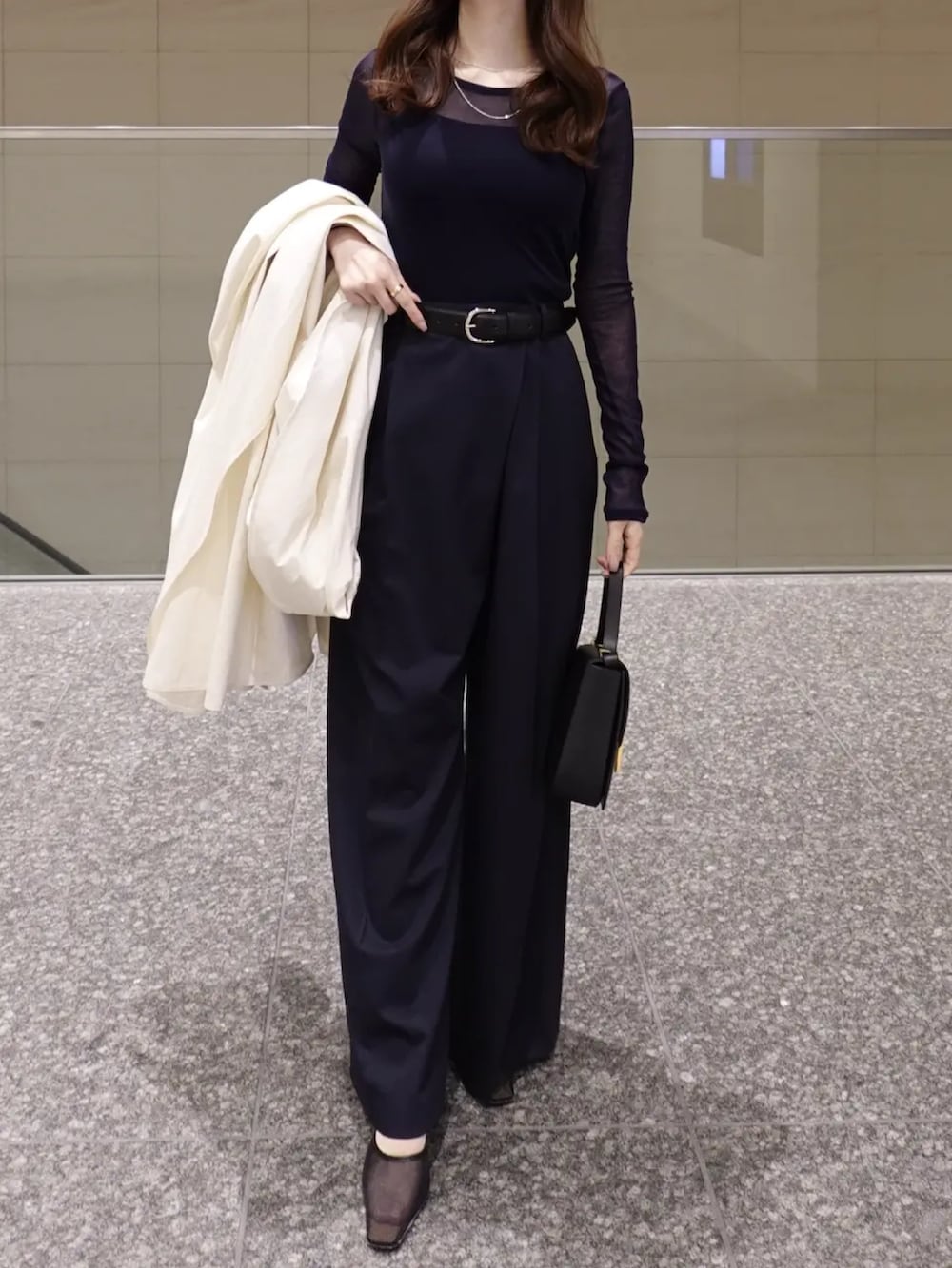 ホワイト系のトレンチコート、ブルー系のTシャツ/カットソー、ブルー系のその他パンツを着用したレディースの冬コーディネートの2枚目の写真