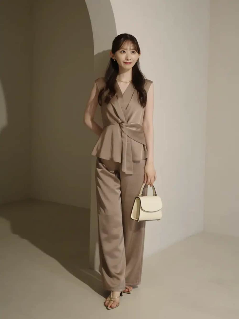 ホワイト系のハンドバッグ、ベージュ系のその他パンツ、ベージュ系のシャツ/ブラウスを着用したレディースの夏コーディネートの2枚目の写真