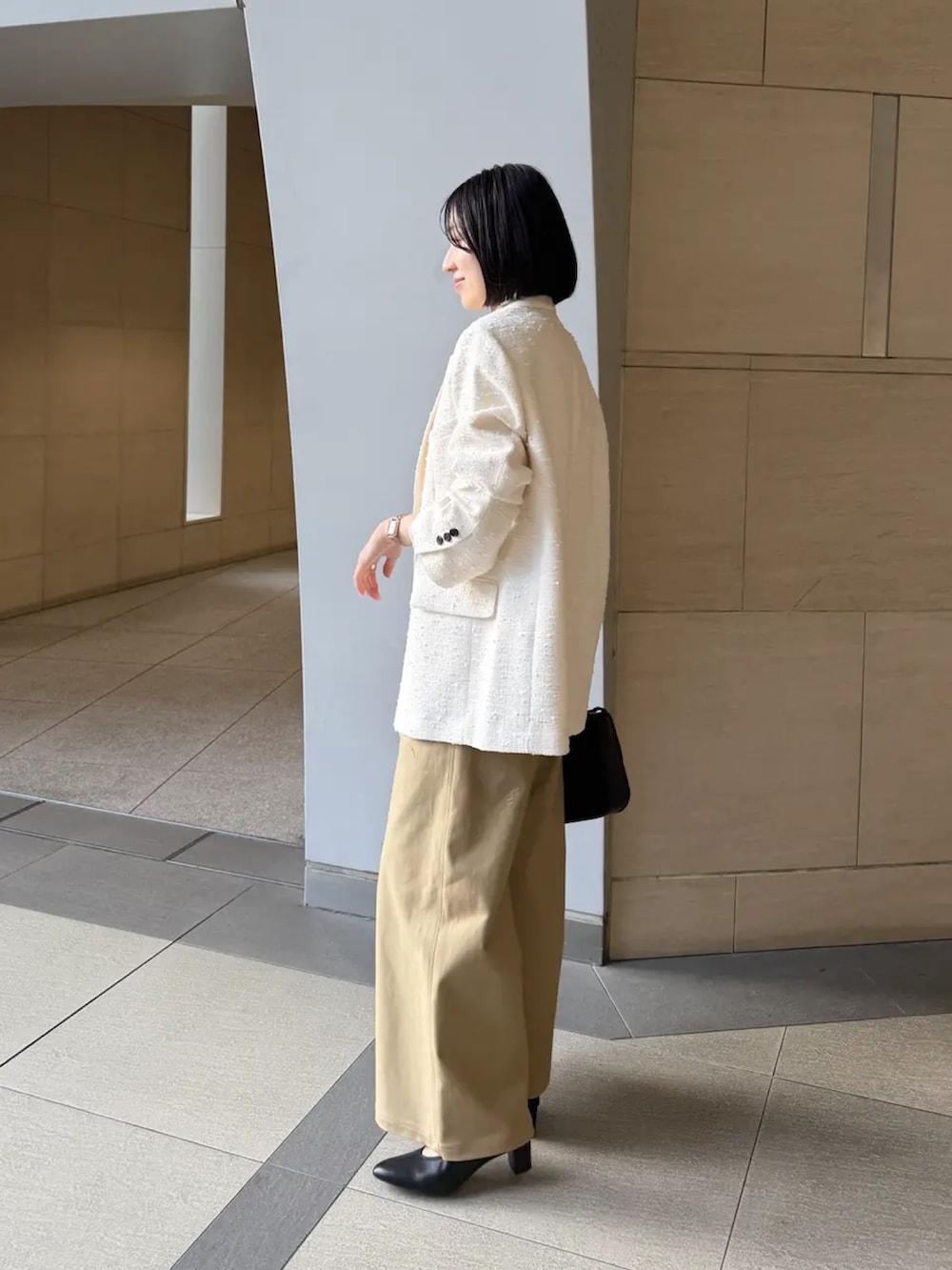 ホワイト系のその他アウター、ホワイト系のTシャツ/カットソー、ベージュ系のその他パンツを着用したレディースの冬コーディネートの4枚目の写真