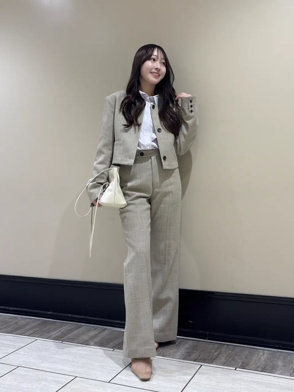 ベージュ系のスラックス、ベージュ系のノーカラージャケット、パープル系のシャツ/ブラウスを着用したレディースの春コーディネートの3枚目の写真