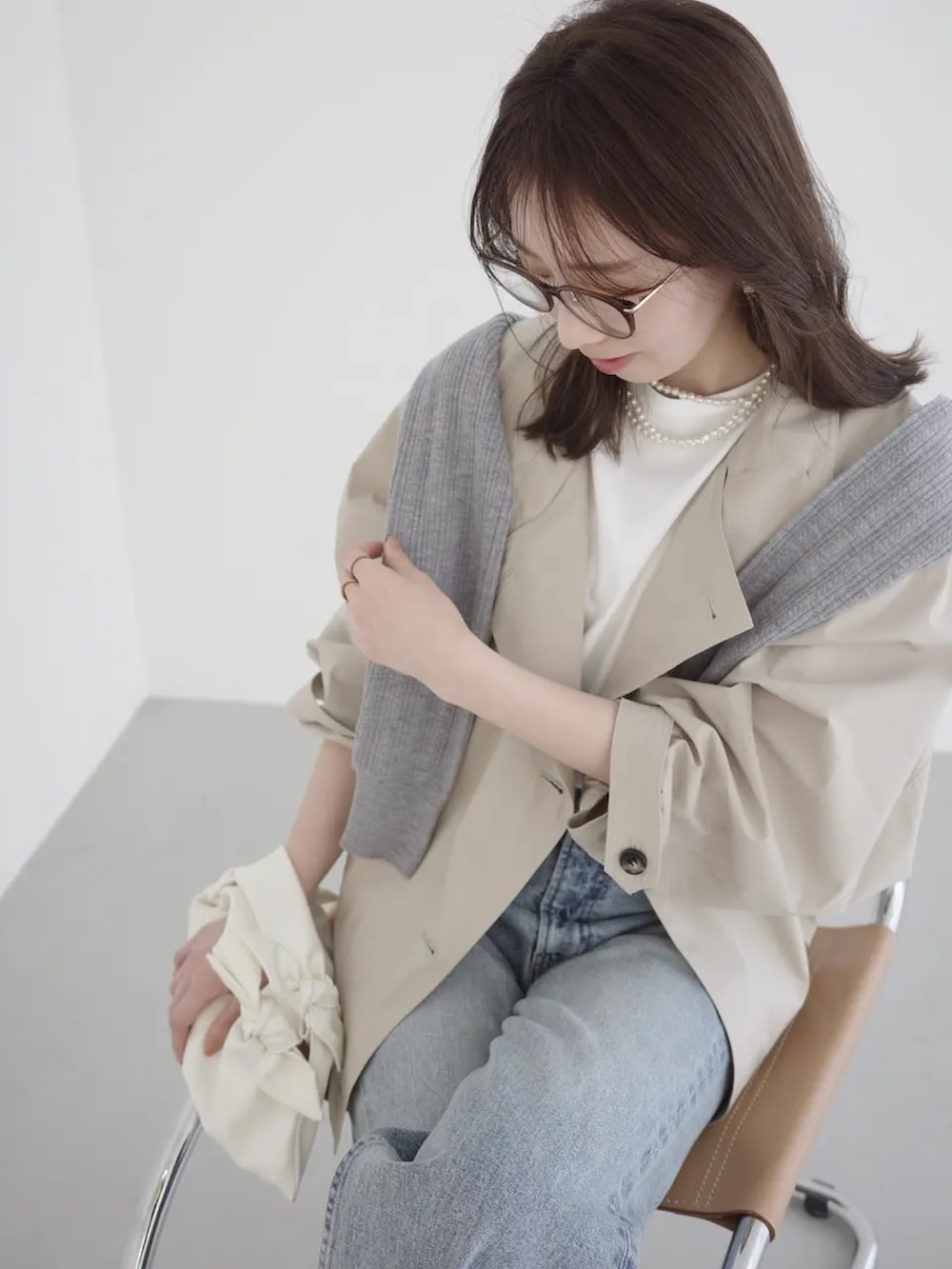 ブルー系のデニムパンツ、ベージュ系のブルゾン、グレー系のカーディガン/ボレロを着用したレディースの春コーディネートの3枚目の写真