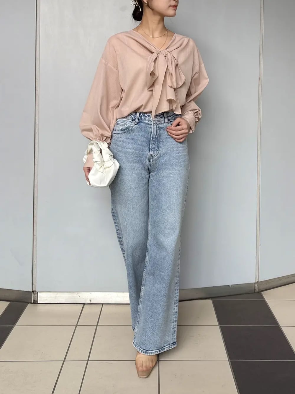 ピンク系のシャツ/ブラウス、ブルー系のデニムパンツを着用したレディースの春コーディネートの2枚目の写真