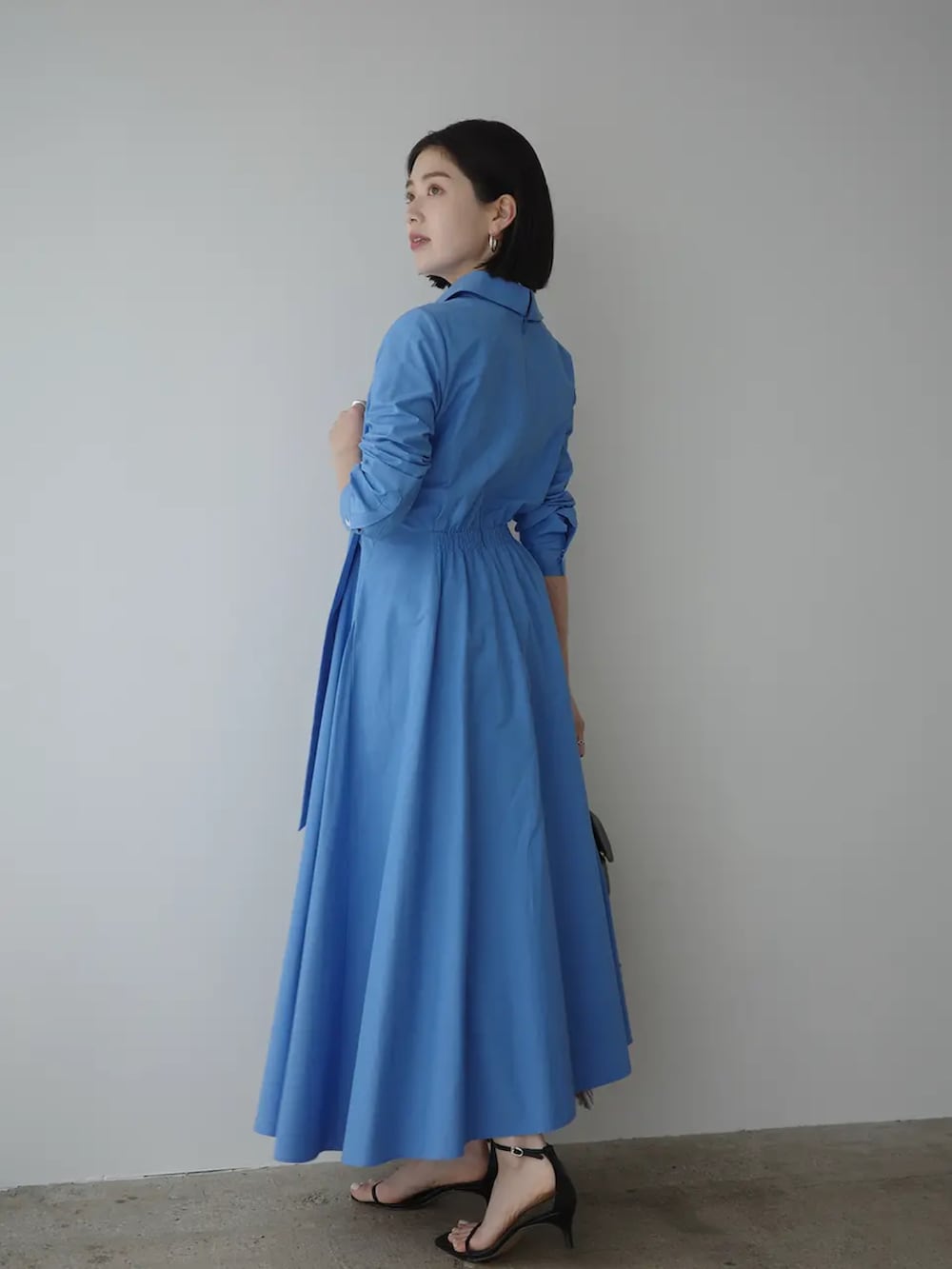 ブルー系のシャツワンピースを着用したレディースの春コーディネートの2枚目の写真