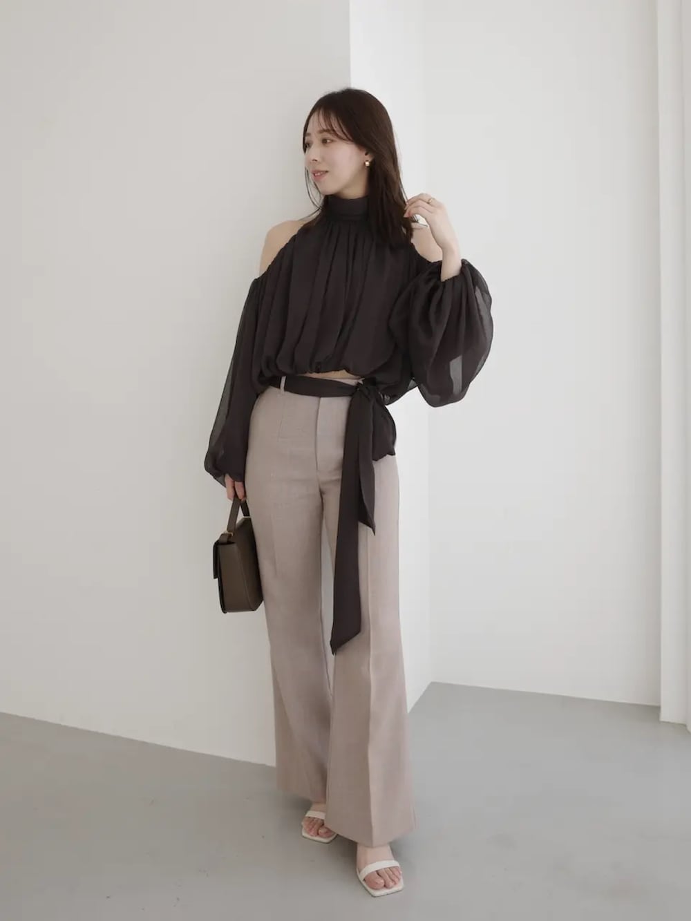 ブラウン系のシャツ/ブラウス、ベージュ系のスラックスを着用したレディースの春コーディネートの2枚目の写真