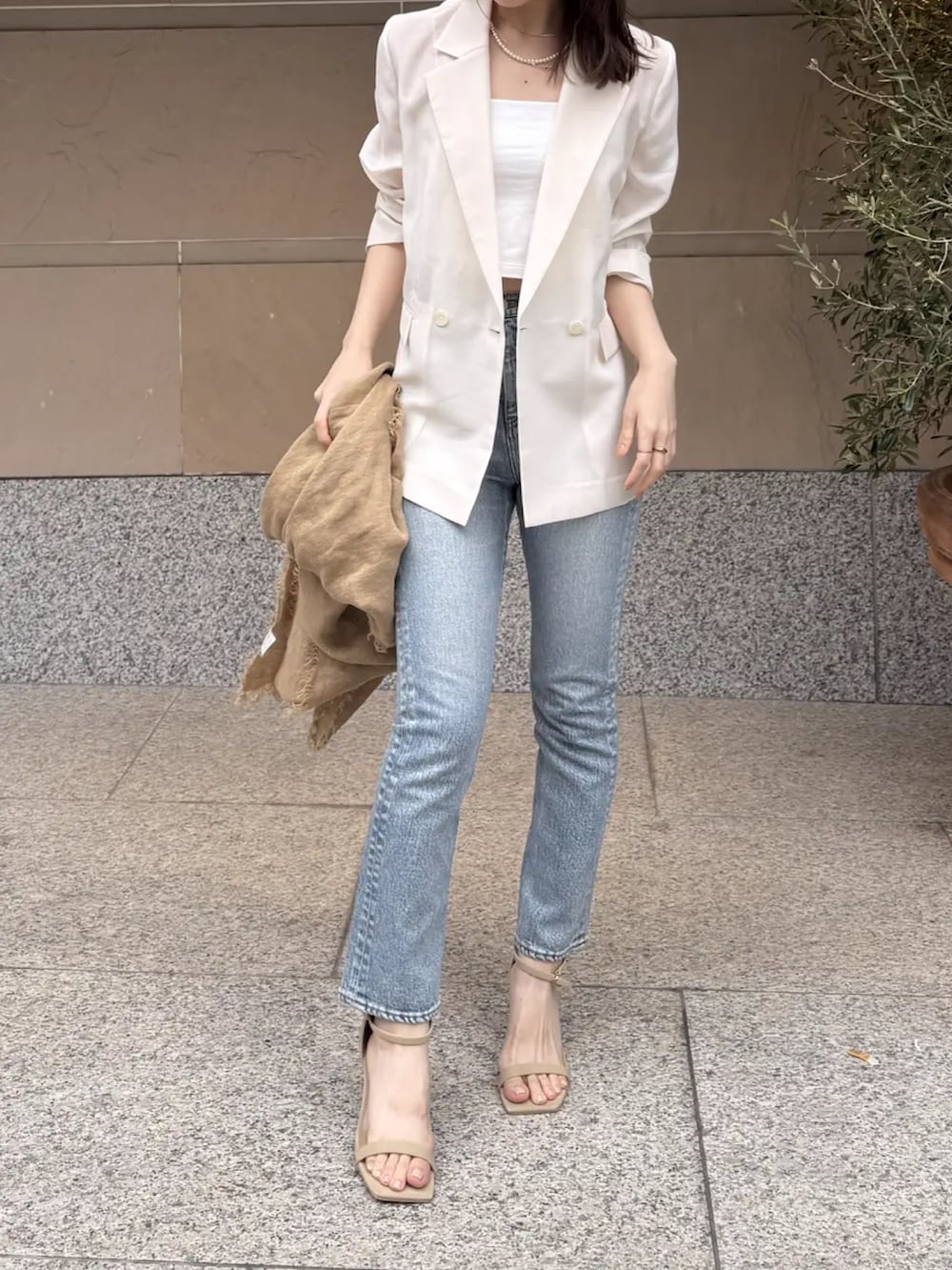 ブルー系のデニムパンツ、ホワイト系のテーラードジャケットを着用したレディースの春コーディネートの2枚目の写真