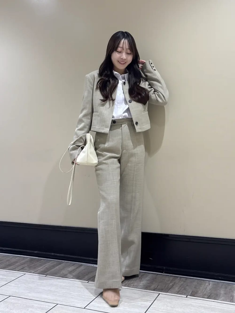 ベージュ系のスラックス、ベージュ系のノーカラージャケット、パープル系のシャツ/ブラウスを着用したレディースの春コーディネートの4枚目の写真