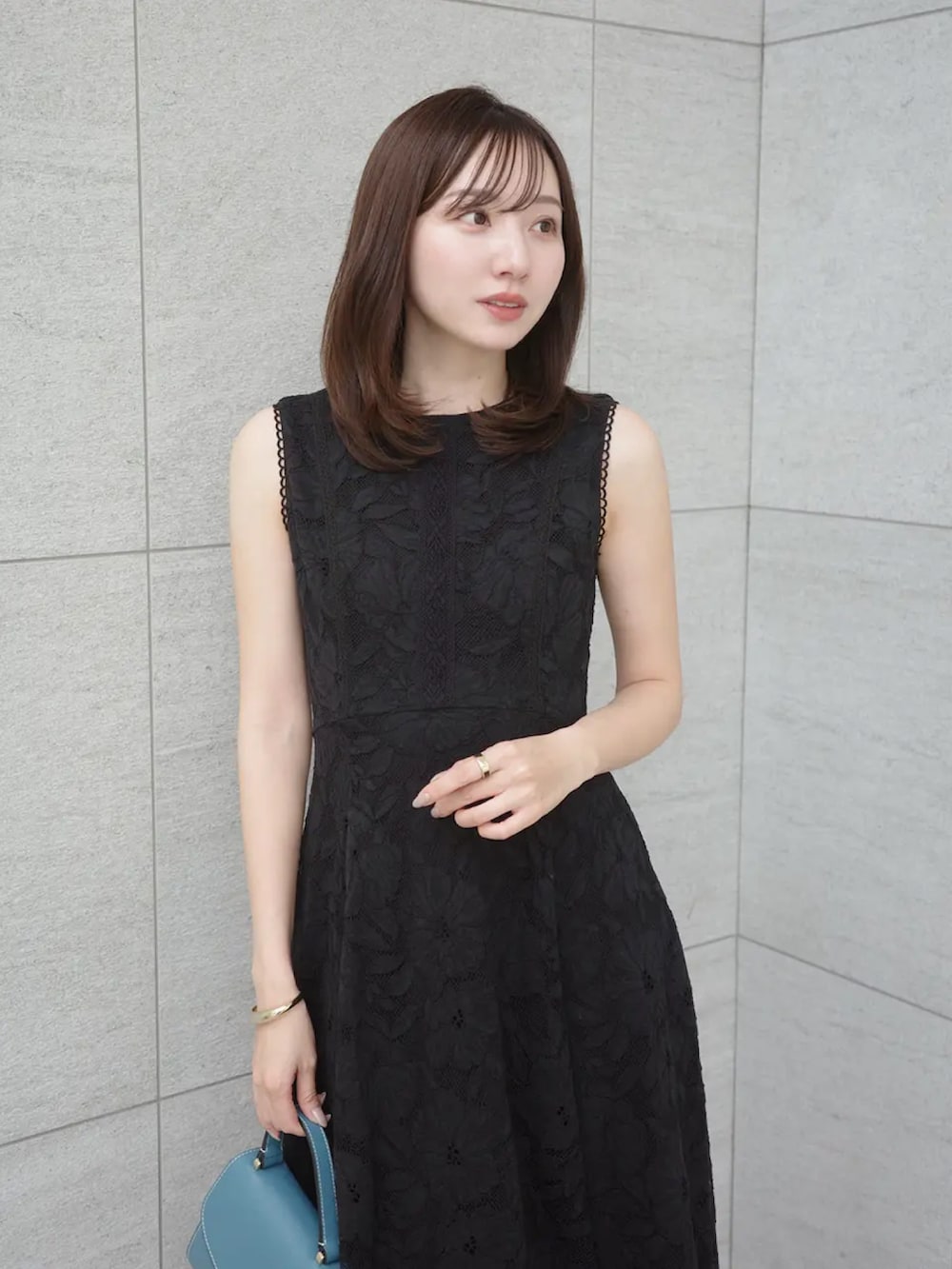 ブラック系のワンピースを着用したレディースの春コーディネートの2枚目の写真