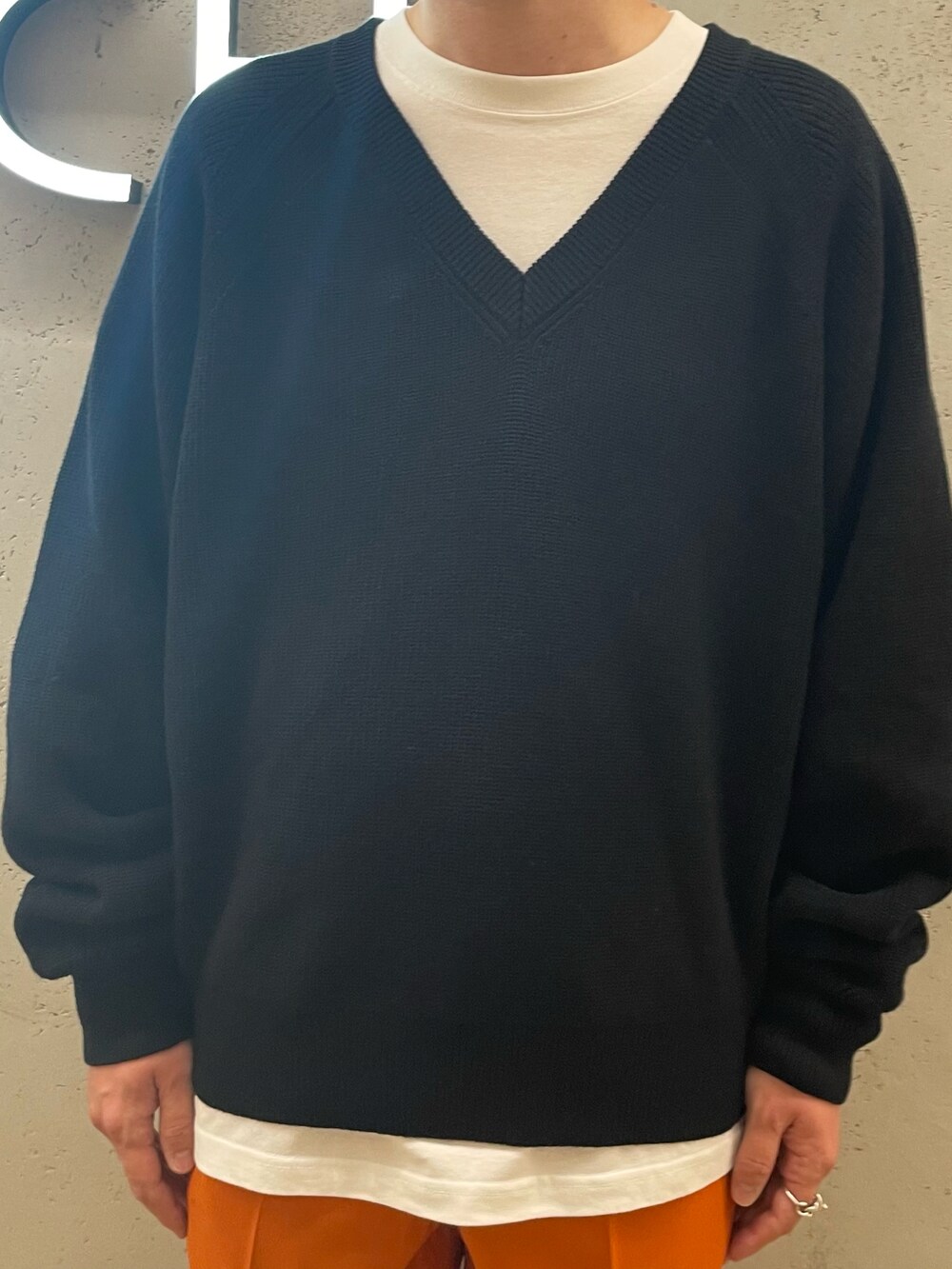 ブラック系のその他シューズ、オレンジ系のその他パンツ、ブラック系のニット/セーターを着用したメンズの冬コーディネートの3枚目の写真