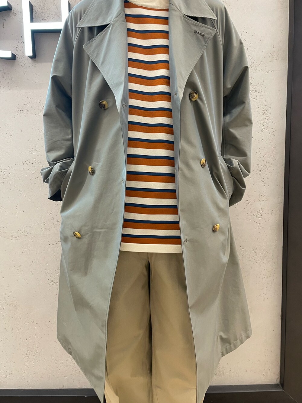 ホワイト系のスニーカー、ベージュ系のその他パンツ、グリーン系のトレンチコートを着用したメンズの冬コーディネートの2枚目の写真