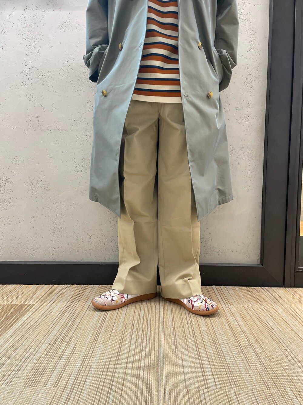 ホワイト系のスニーカー、ベージュ系のその他パンツ、グリーン系のトレンチコートを着用したメンズの冬コーディネートの3枚目の写真