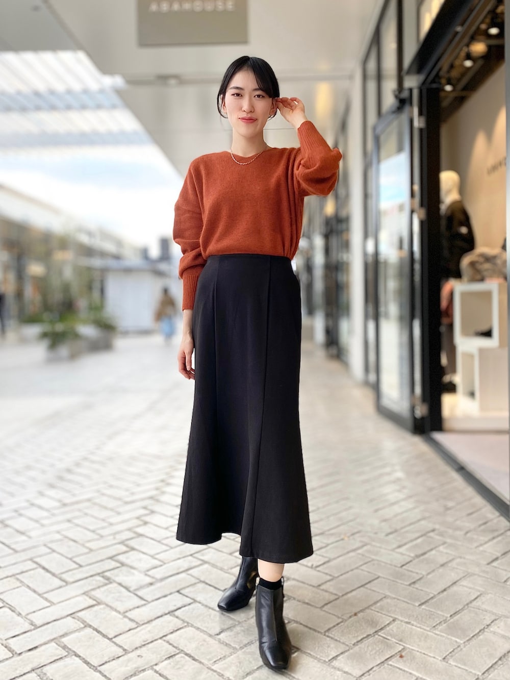 ホワイト系のMA-1、ブラック系のスカート、オレンジ系のニット/セーターを着用したレディースの秋コーディネートの2枚目の写真